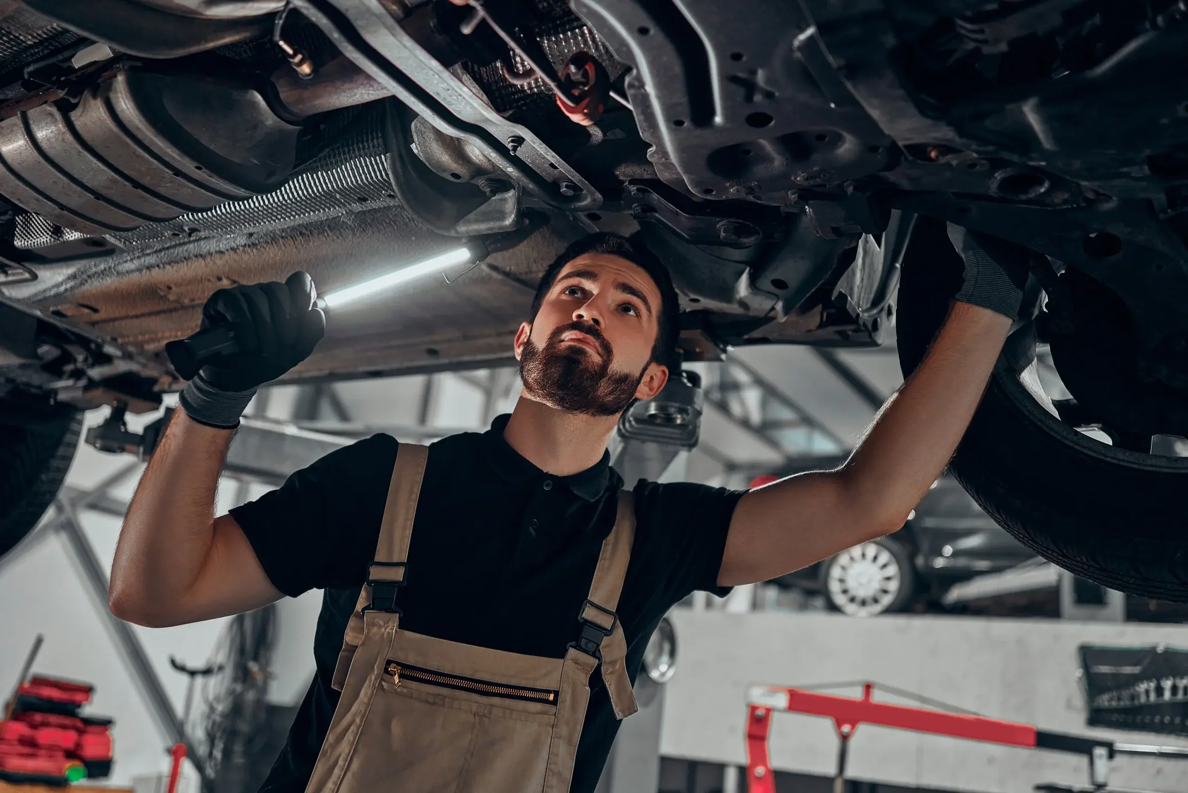 Mechanic checking the underside of a raised vehicle