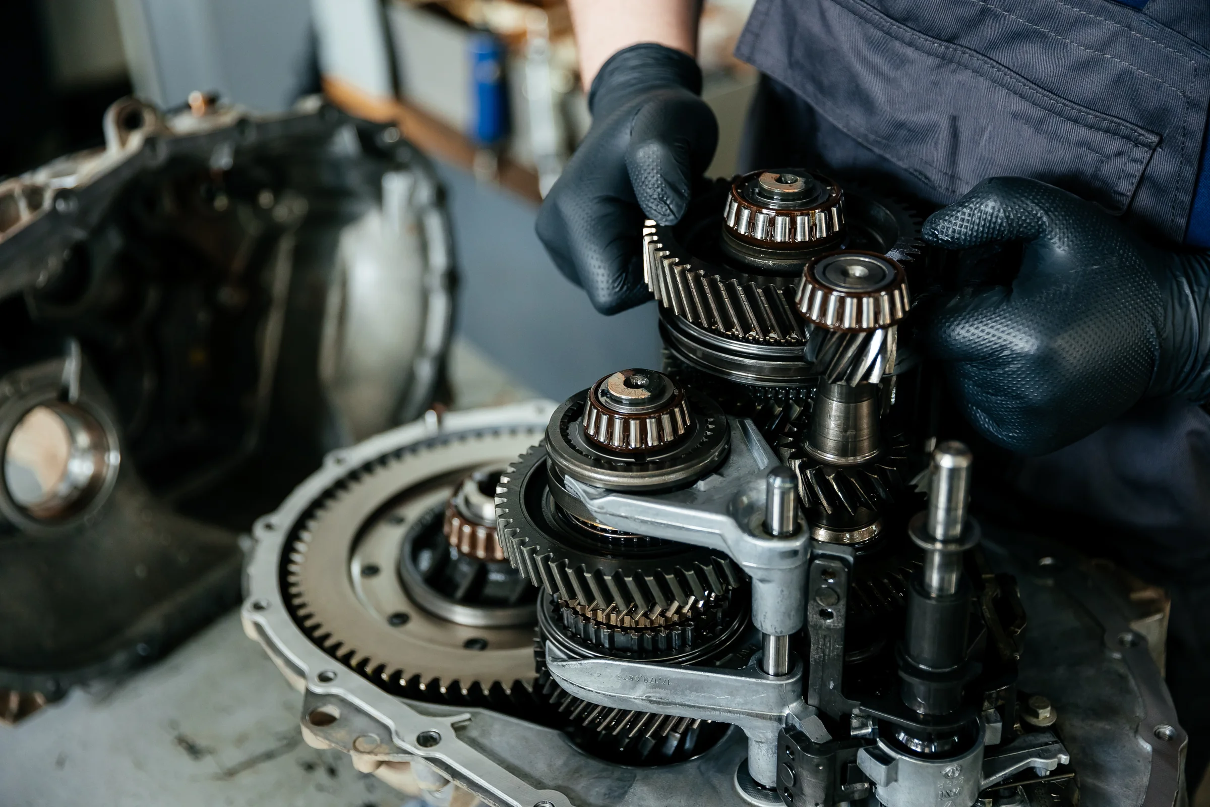 Hands inspecting transmission gears on a workbench